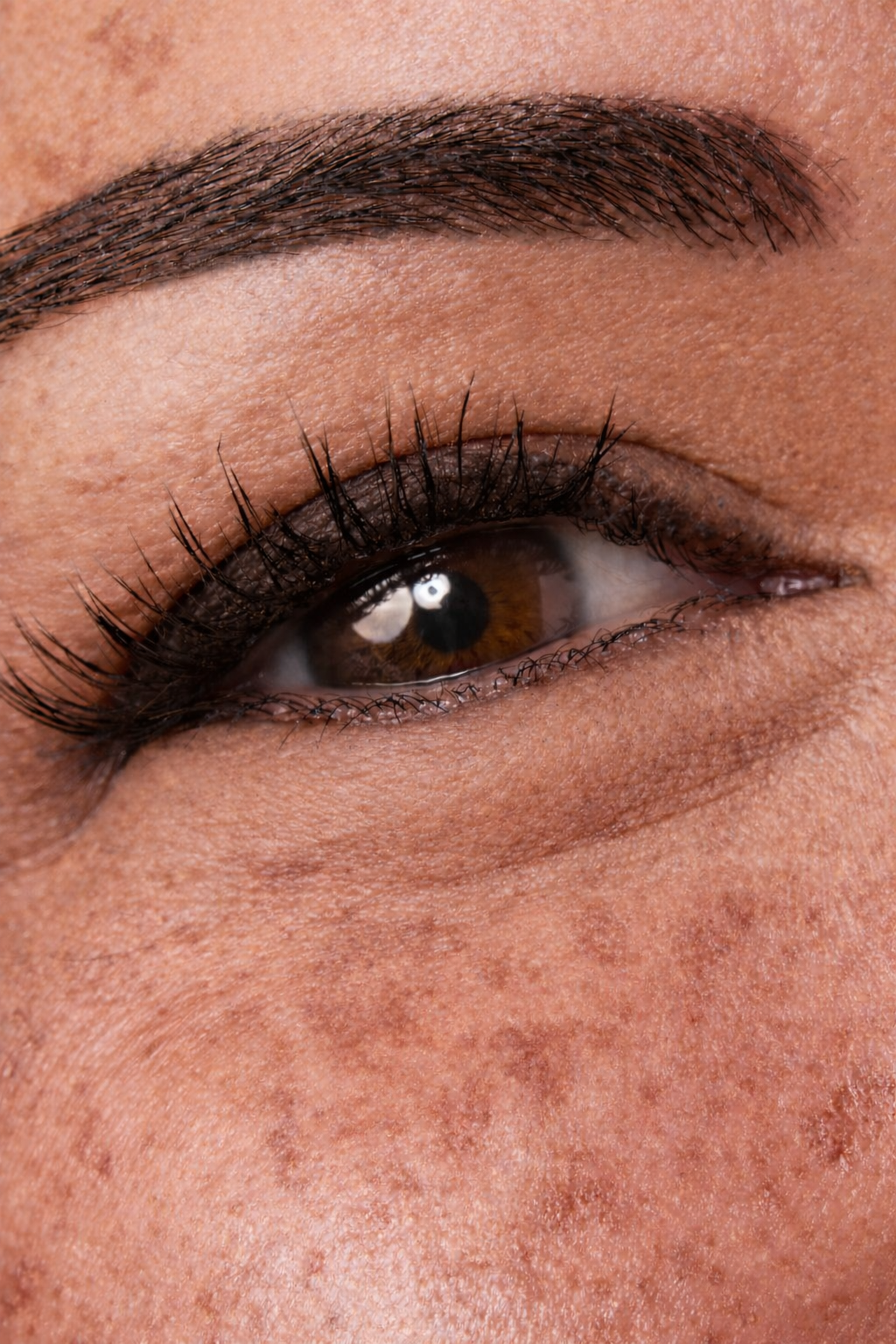 Close-up of a person's eye with dark brown eyeliner.