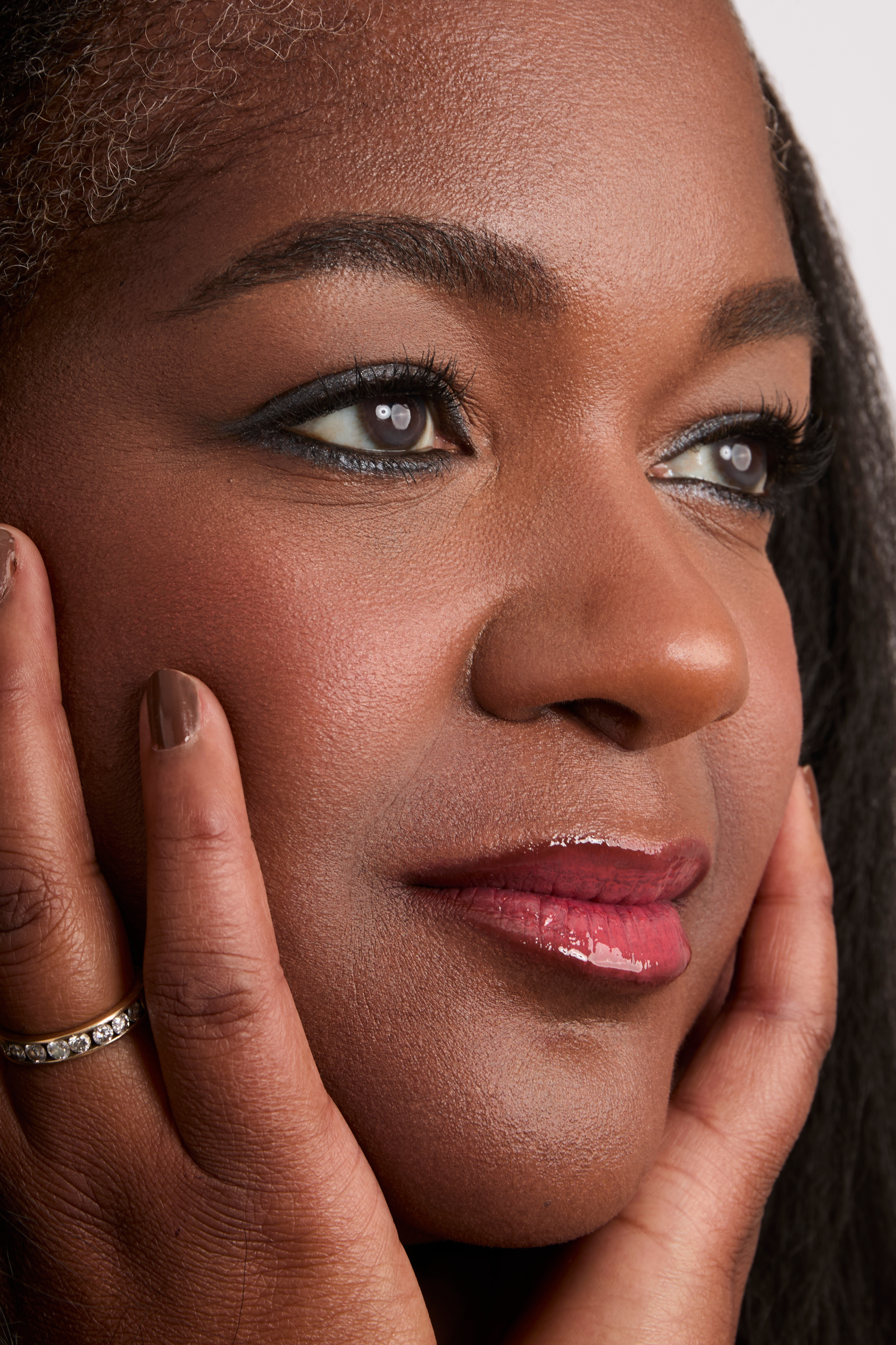 Close-up of a woman with her hands on her face, wearing Steel Gray Eyeliner.