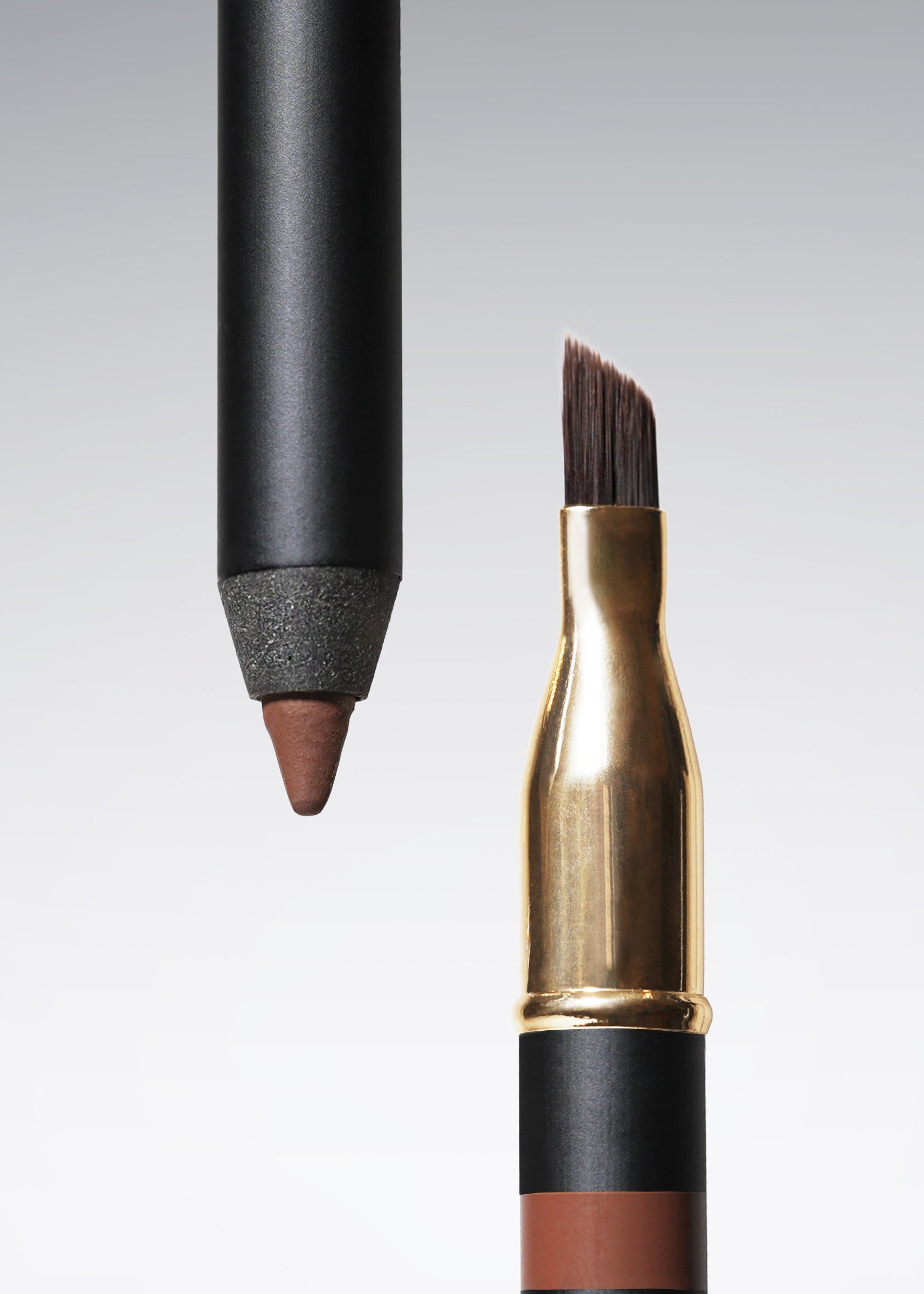 A close-up studio shot of eyeliner showing two views of the same item: a pencil tip above and the angled brush below, revealing a chocolate brown cosmetic formula inside a gold and black tube on a light gray gradient background.
