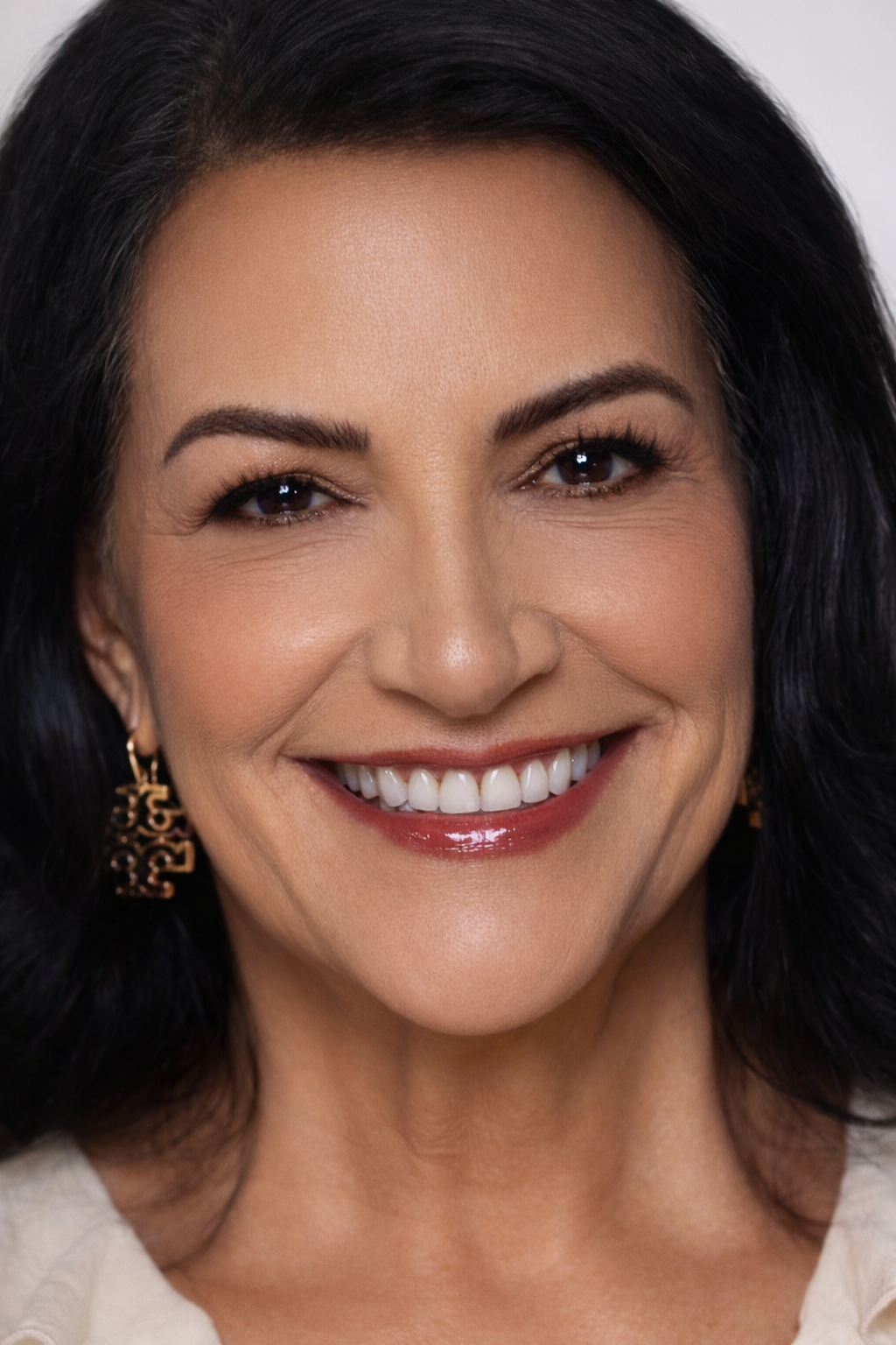 Close-up of a woman with a bright smile, wearing chocolate Brown eyeliner.