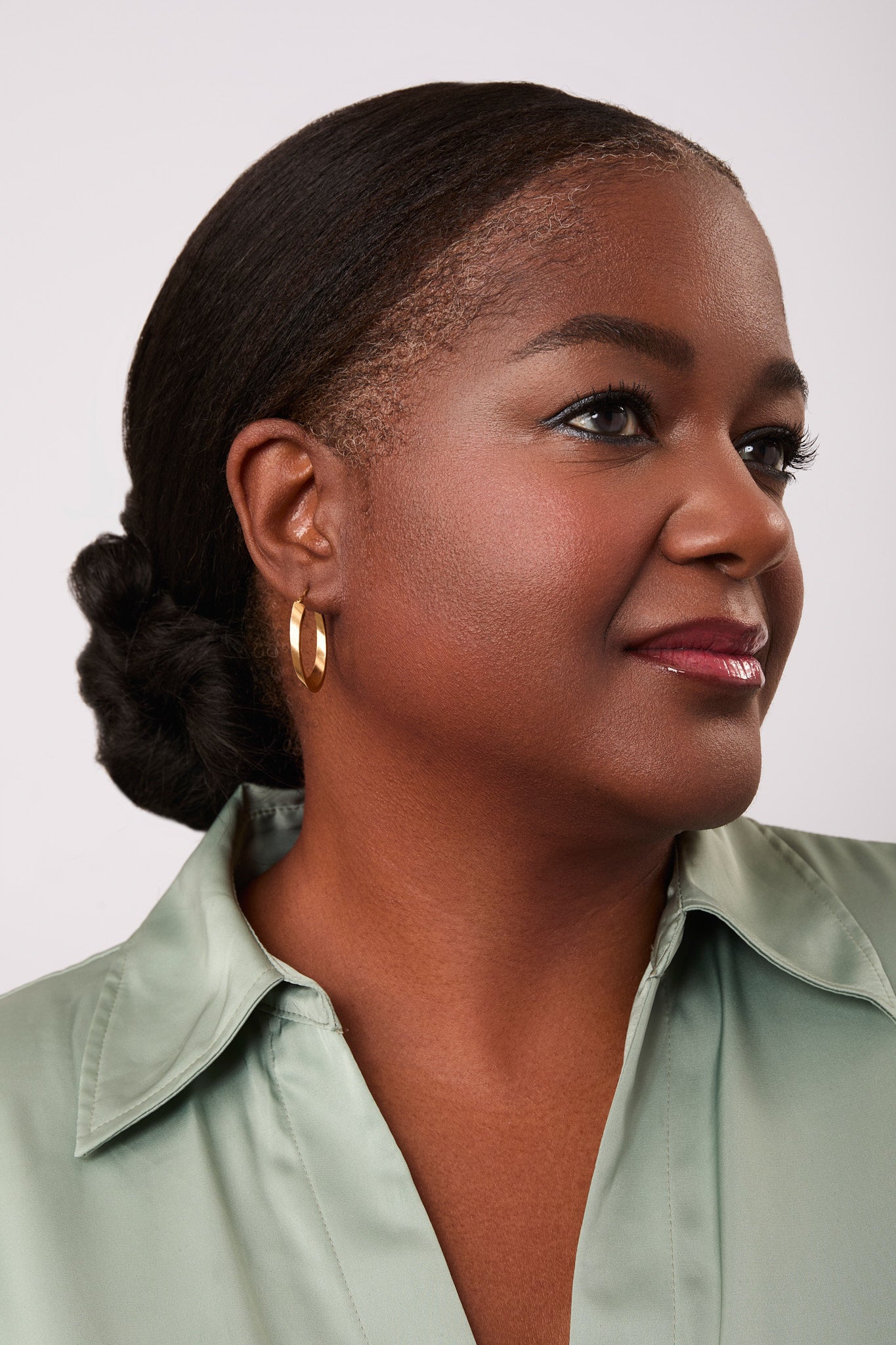 Woman with hair tied back wearing a green shirt and Steel Gray Eyeliner.